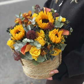 Композиция в сумке "Тональность" из подсолнухов, калл, ягод вибирнума, лимонных роз, скиммии и орхидеи в Можайске