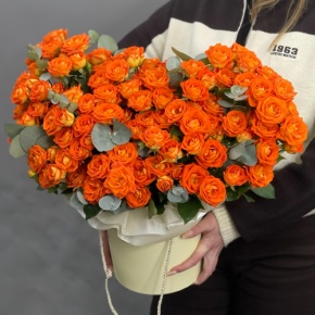 Композиция в шляпной коробке "Закат" из кустовых роз и эвкалипта в Можайске